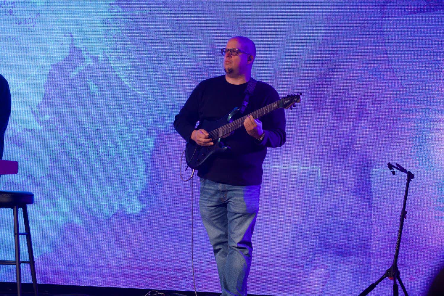 Frank Torres on stage in front of a blue LED wall